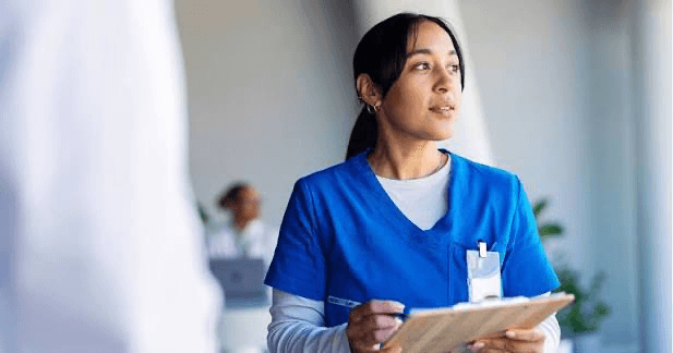 A healthcare professional using a tablet at a nurses’ station