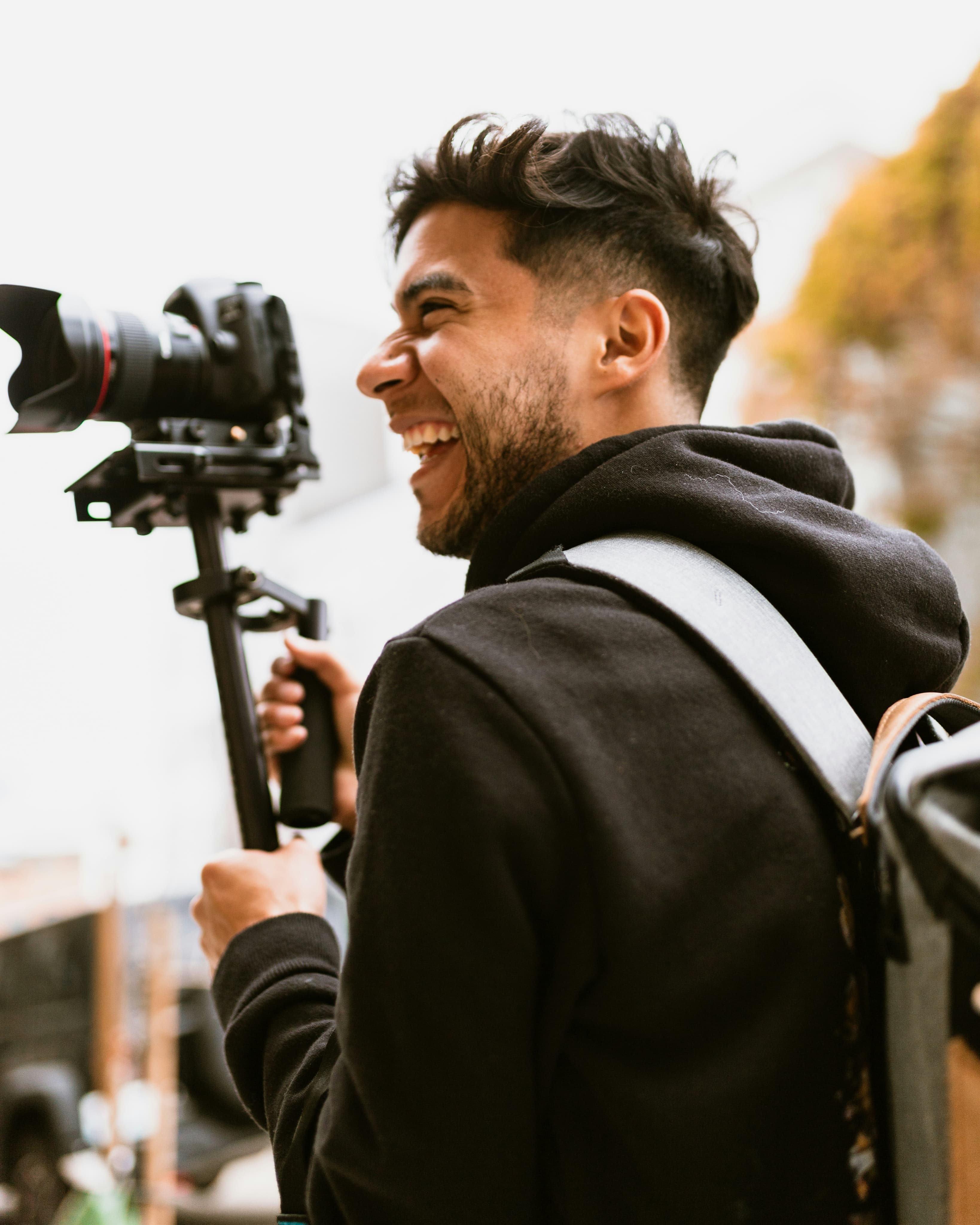 Smiling video editor with a stabilized camera rig